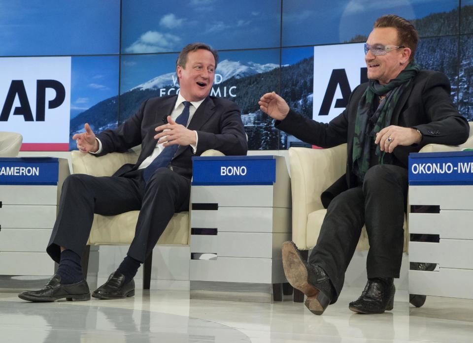 British Prime Minister David Cameron, left, and rock star Bono speak during the panel discussion "The Post-2015 Goals: Inspiring a New Generation to Act", the fifth annual Associated Press debate, at the World Economic Forum in Davos, Switzerland, Friday, Jan. 24, 2014. (AP Photo/Michel Euler)