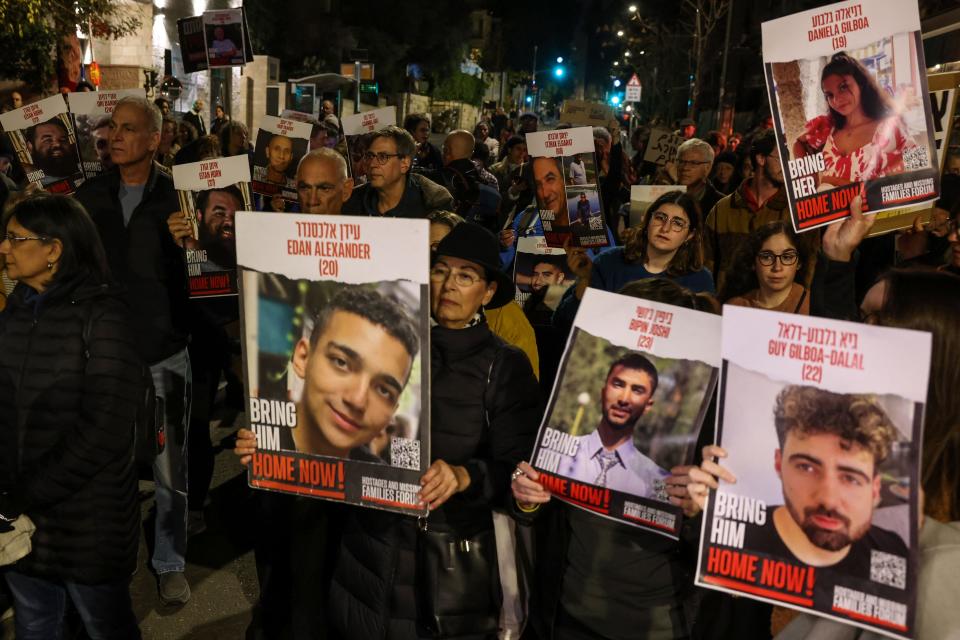 Protesters hold up portraits during a rally organized by family and supporters of Israeli hostages near the residence of the Israeli prime minister in Jerusalem on Jan. 22, 2024.