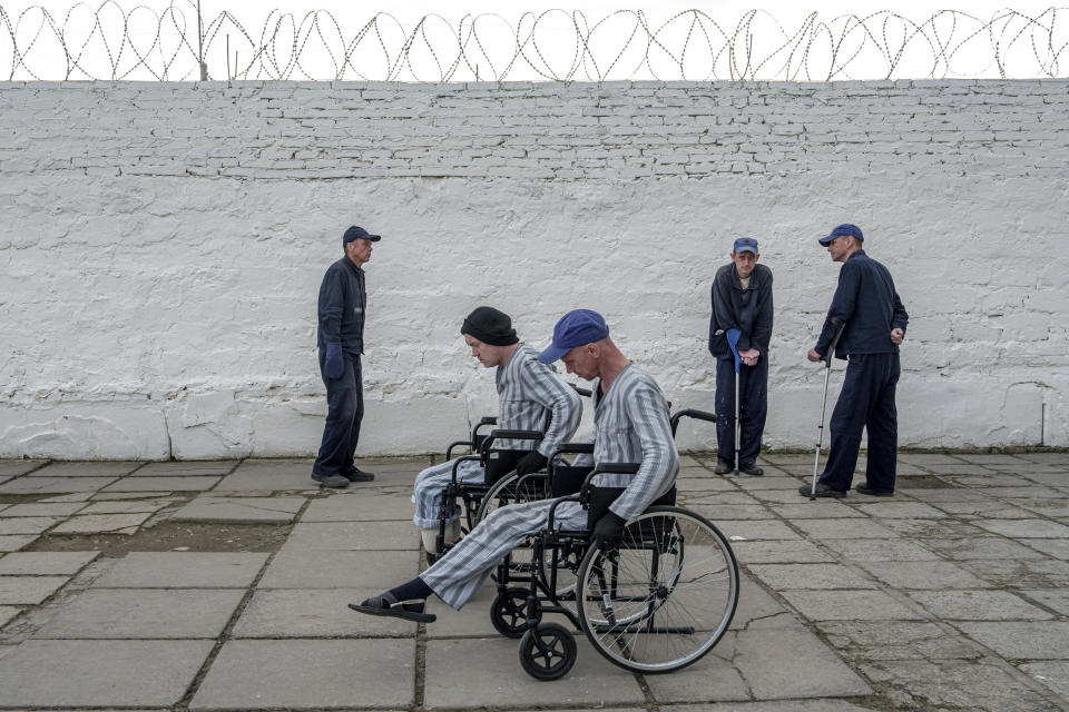 Injured Russian soldiers use wheelchairs at the prisoner of war detention center in Ukraine's Lviv region, Thursday, April 25, 2024. AP visited the center as part of a small group of journalists on the condition that its exact location be withheld. (AP Photo/Evgeniy Maloletka)