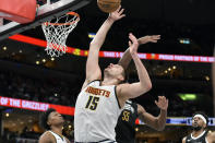 Denver Nuggets center Nikola Jokic (15) reaches for the ball in the first half of an NBA basketball game against the Memphis Grizzlies, Sunday, April 14, 2024, in Memphis, Tenn. (AP Photo/Brandon Dill)