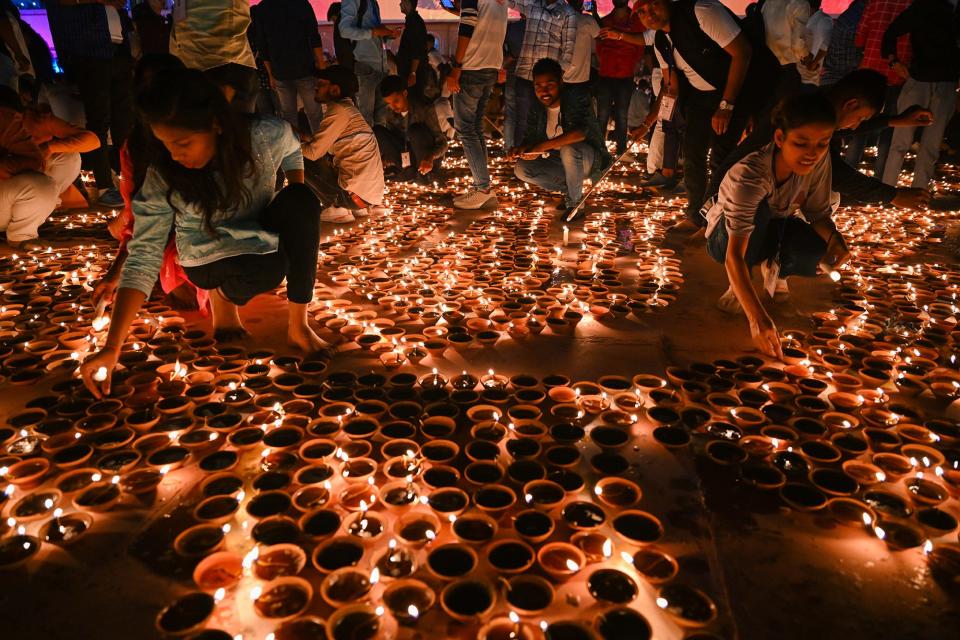 People light earthen lamps on the banks of Saryu River during a cultural program, on the eve of Diwali festival, on November 11, 2023, Ayodhya, India.