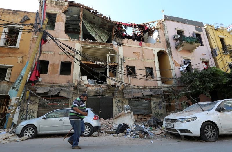 A man walks past rubble of damaged buildings following Tuesday's blast at Beirut's port area