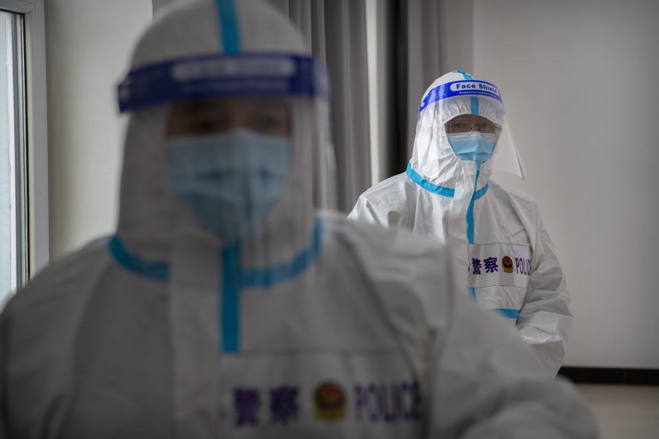 Security officers in protective suits stand in a hallway with rooms for video meetings with inmates at the visitors' hall at the Urumqi No. 3 Detention Center in Dabancheng in western China's Xinjiang Uyghur Autonomous Region on April 23, 2021. (AP Photo/Mark Schiefelbein)