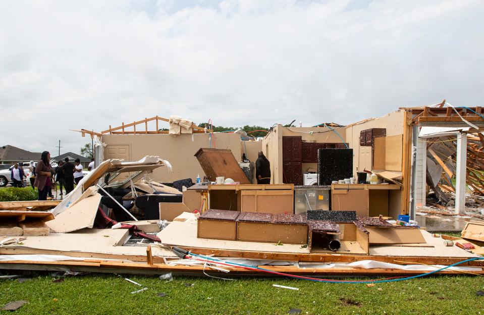 Neighbors inspect a house for occupants in Monroe, La. after an Easter tornado ripped through the town just before noon on April 12, 2020. (Nicolas Galindo/The News-Star via AP) ORG XMIT: LAMON206