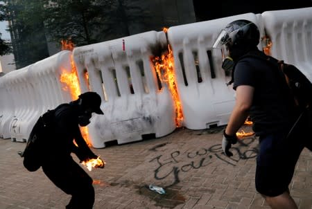 An anti-government protester catches fire after throwing Molotov cocktail during a demonstration near Central Government Complex in Hong Kong