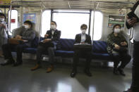 Passengers wearing face masks to protect against the spread of the new coronavirus ride on a train in Yokohama near Tokyo, Wednesday, April 8, 2020. The new coronavirus causes mild or moderate symptoms for most people, but for some, especially older adults and people with existing health problems, it can cause more severe illness or death. (AP Photo/Koji Sasahara)