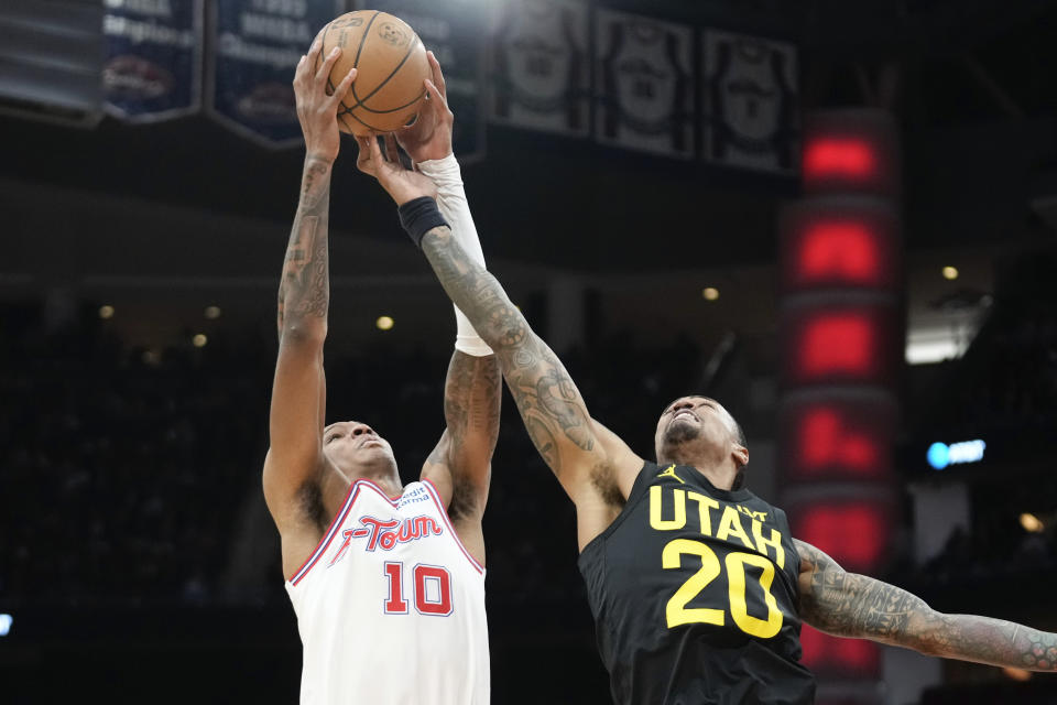 Houston Rockets forward Jabari Smith Jr. (10) and Utah Jazz forward John Collins (20) reach for a rebound during the first half of an NBA basketball game Saturday, Jan. 20, 2024, in Houston. (AP Photo/Eric Christian Smith)