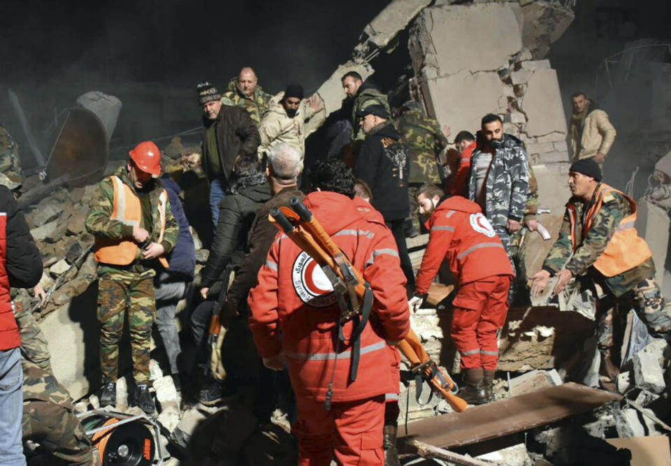 In this photo released by the Syrian official news agency SANA, Syrian security forces and civil defence workers search for victims under the rubbles of a building that was destroyed by Israeli airstrikes, in Homs, Syria, late Tuesday, Feb. 6, 2024. Syria's military says Israeli airstrikes over the central city of Homs and nearby areas have killed and wounded civilians. (SANA via AP)