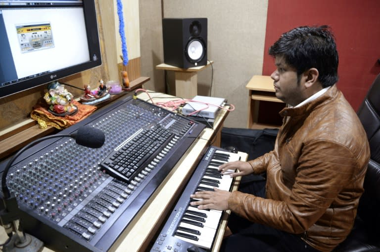 Indian music director Amarjit Singh plays a keyboard during a recording session with Indian singer Ginni Mahi at a studio in Jalandhar