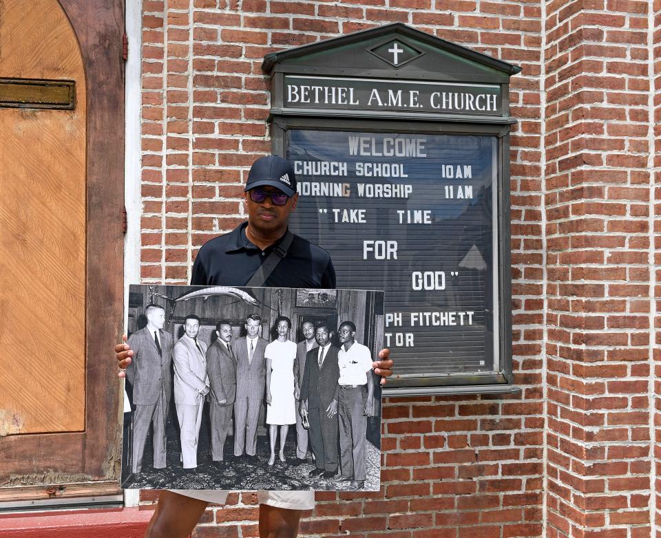 Dion Banks holds a photo of the people invovled in the Cambridge Treaty signing in front of Bethel AME Church July 14, 2023, in Cambridge, Maryland.