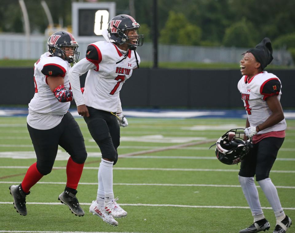 Vertus quarterback Casmier Bradford Sawyer (7) celebrates with teammates Khalid Osbourne and Zyi'Shohn Mayo-Stokes as time expires giving the Warriors the win over Rochester Prep/Eugenio Maria de Hostos 28-8 during their Section V season opener Saturday at Gates Chili High School. The win was the first ever for Vertus Charter, now starting their second season of Section V football.