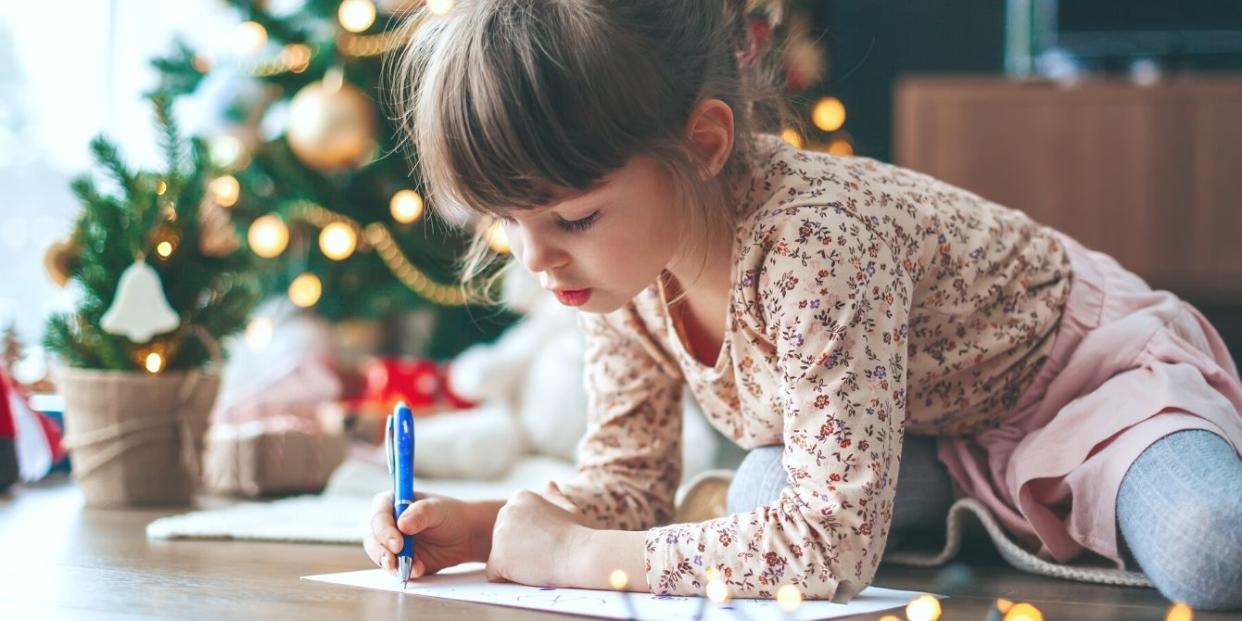 Little girl writing Christmas list to Santa