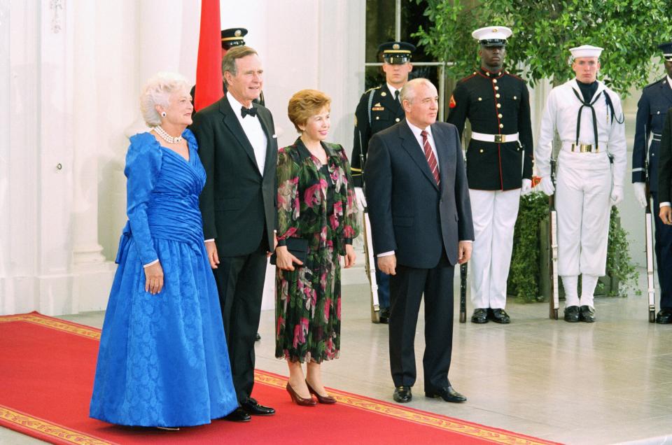 FILE - President George Bush and his wife Barbara, pose with Soviet President Mikhail Gorbachev and his wife, Raisa, as they arrive for the state dinner at the White House in Washington on Thursday, May 31, 1990. When Mikhail Gorbachev is buried Saturday at Moscow's Novodevichy Cemetery, he will once again be next to his wife, Raisa, with whom he shared the world stage in a visibly close and loving marriage that was unprecedented for a Soviet leader. Gorbachev's very public devotion to his family broke the stuffy mold of previous Soviet leaders, just as his openness to political reform did. (AP Photo/J. Scott Applewhite, File)