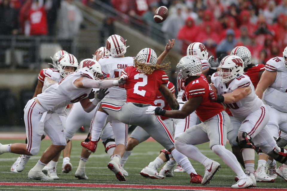 Ohio State defenders Chase Young (2) and Tyreke Smith (11) cause Wisconsin quarterback Jack Coan to fumble the ball on fourth down during the second half of an NCAA college football game Saturday, Oct. 26, 2019, in Columbus, Ohio. Ohio State beat Wisconsin 38-7. (AP Photo/Jay LaPrete)