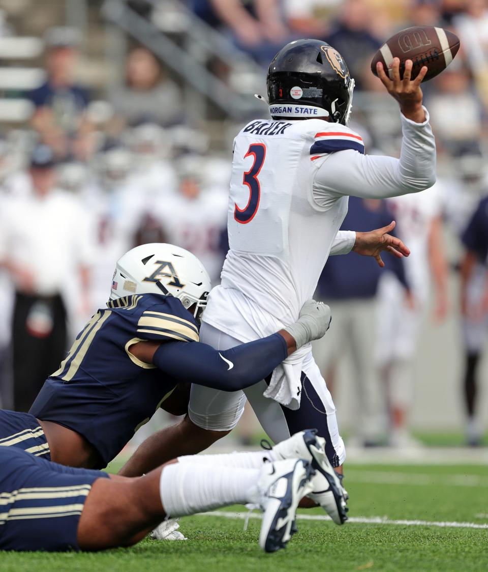 Akron Zips defensive lineman CJ Nunnally IV brings down Morgan State Bears quarterback Carson Baker as he throws in the first half Saturday in Akron.