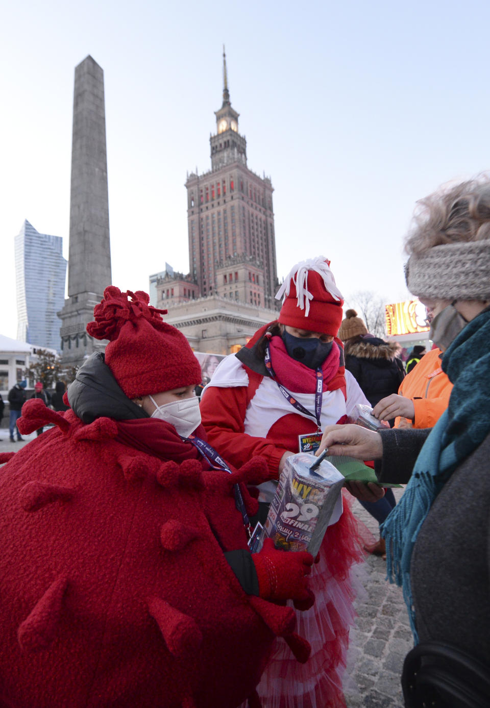 A child in a red costume collects money for Poland's most popular nationwide fundraiser for health purposes, the Great Orchestra of Christmas Charity, that was postponed by two weeks due to the pandemic, in downtown Warsaw, Poland, on Sunday, Jan. 31, 2021. Anti-government protesters angry about a near-total abortion ban suspended their marches for the weekend to show solidarity and ensure that they didn't steal the spotlight from the event. (AP Photo/Czarek Sokolowski)