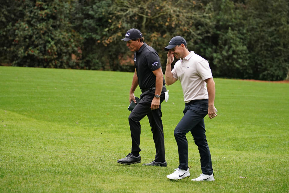 Phil Mickelson, left, and Rory McIlroy, of Northern Ireland, walk to the 11th tee during a practice round for the Masters golf tournament Tuesday, Nov. 10, 2020, in Augusta, Ga. (AP Photo/Matt Slocum)