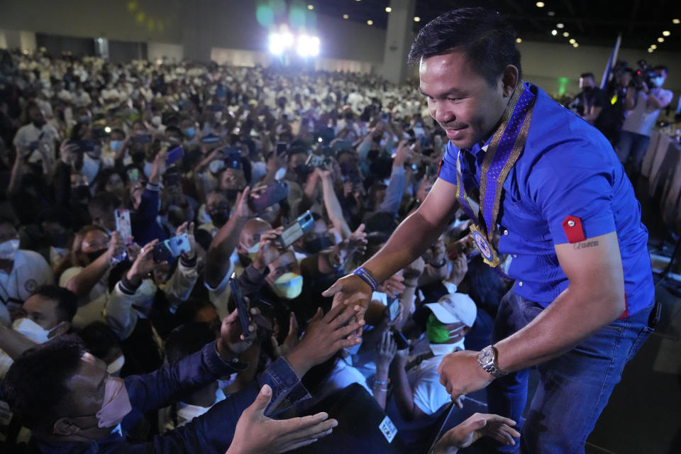 Boxing legend and presidential candidate, senator Manny "Pacman" Pacquiao greets the crowd in Pasay city, Philippines on March 14, 2022. The winner of May 9, Monday's vote will inherit a sagging economy, poverty and deep divisions, as well as calls to prosecute outgoing leader Rodrigo Duterte for thousands of deaths as part of a crackdown on illegal drugs. (AP Photo/Aaron Favila)