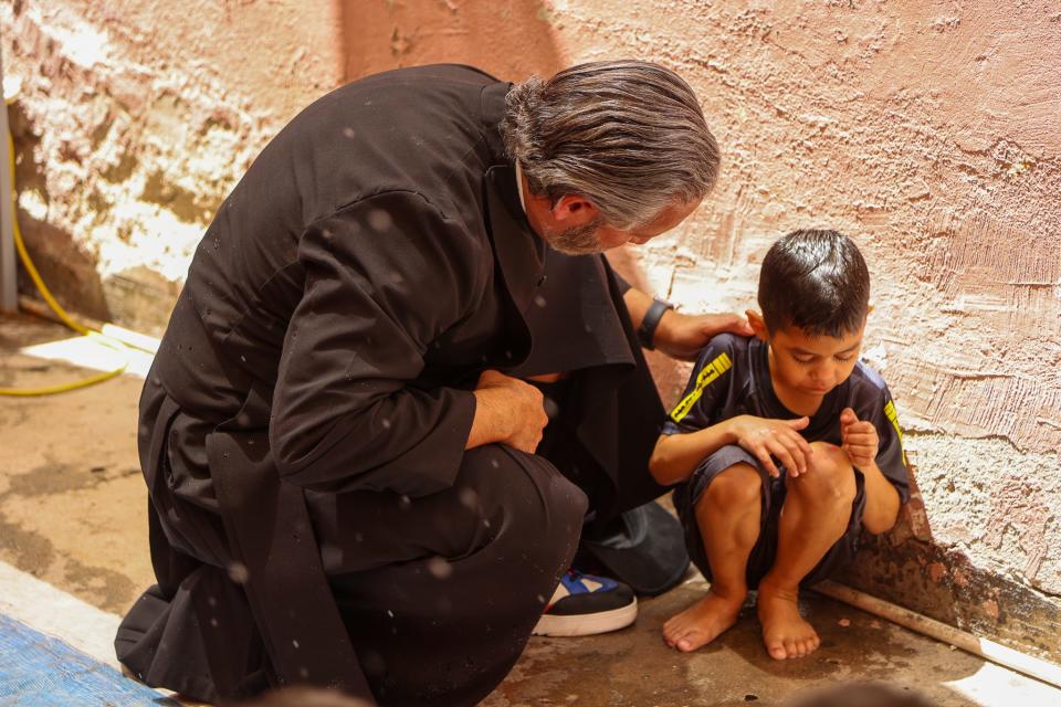 Episcopal priest Lorenzo Lebrija speaks with a child at a shelter in Mexico.