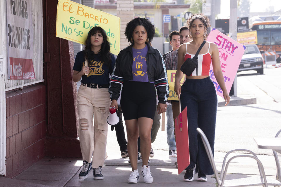 Julissa Calderón walks among activists on a city sidewalk in a production still of 