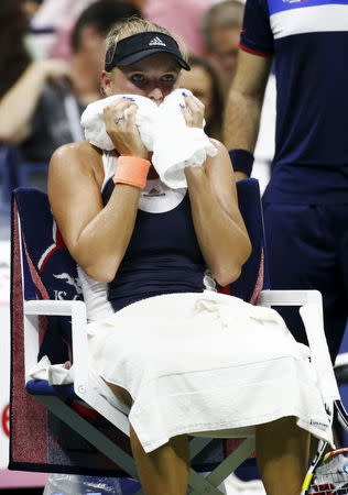 Caroline Wozniacki of Denmark holds a towel over her face during her match with Petra Cetkovska of Czech Republic at the U.S. Open Championships tennis tournament in New York, September 3, 2015. REUTERS/Shannon Stapleton