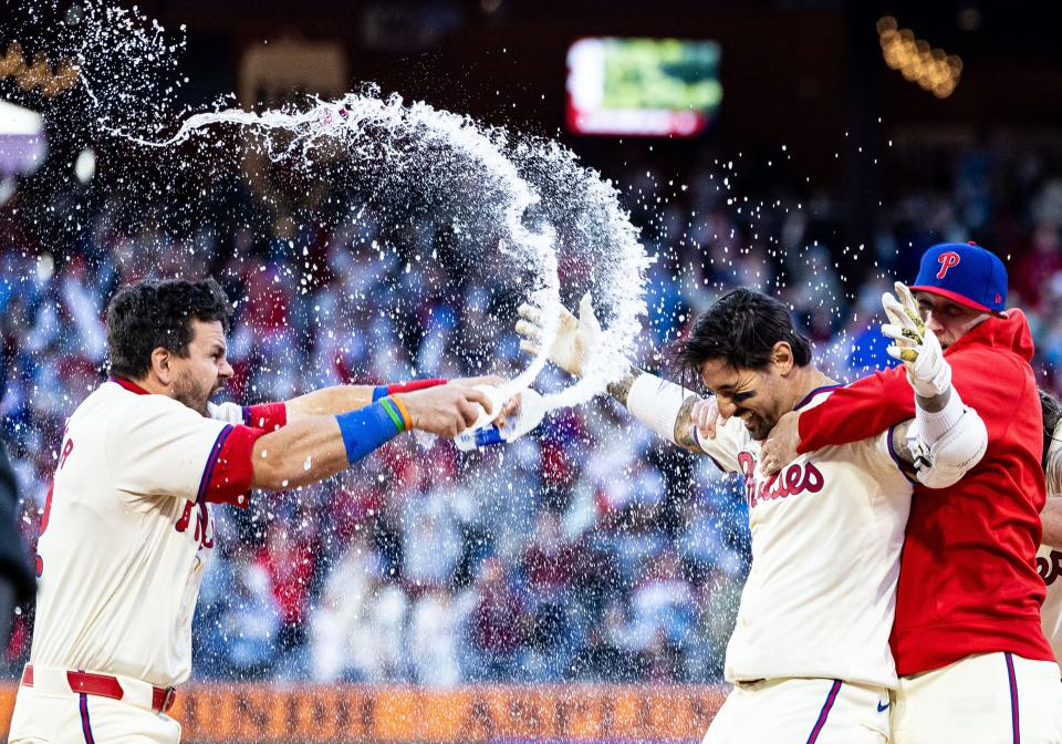 Philadelphia Phillies outfielder Nick Castellanos (8) is douse with water by designated hitter Kyle Schwarber (12) after hitting an RBI single during the ninth inning against the Pittsburgh Pirates Saturday, April 13, 2024, at Citizens Bank Park in Philadelphia.