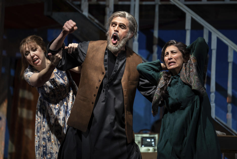 Maureen McKay, left, who portrays Laila, John Moore, who portrays Rasheed, and Karin Mushegain, who portrays Mariam, perform in a dress rehearsal for the opera "A Thousand Splendid Suns," in Seattle, on Wednesday, Feb. 22, 2023. Making its world debut Saturday, Feb. 25, 2023, it is based on a popular novel by Kabul-born author Khaled Hosseini that explores the inner worlds of Mariam and Laila over decades of Afghan history, some with stark parallels to the present. (AP Photo/Stephen Brashear)