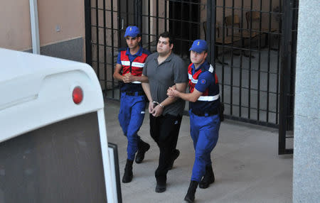 Dimitris Kouklatzis, one of two Greek soldiers who were detained after crossing the border into Turkey, is escorted by Turkish gendarmes as he leaves from a courthouse in Edirne, Turkey August 14, 2018. REUTERS/Ilkyaz Savas