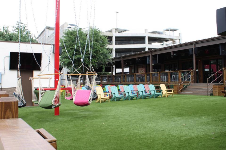 Outdoor lawn patio furniture at Little Woodrow’s first Fort Worth location include adirondack chairs and hammock seats.