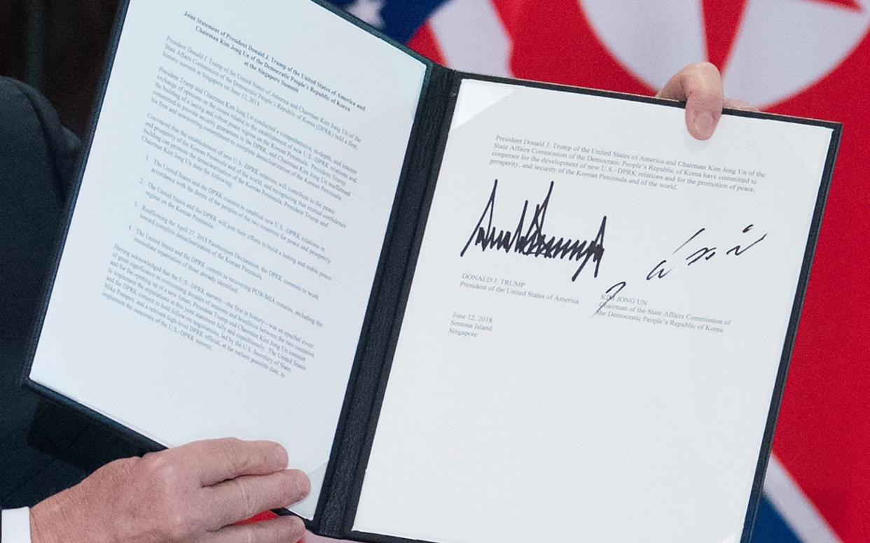 President Trump holds up the document after Tuesday's meeting in Singapore - AFP