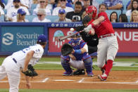 Philadelphia Phillies' Rhys Hoskins, right, hits a solo home run as Los Angeles Dodgers starting pitcher Clayton Kershaw, left, watches along with catcher Austin Barnes, second from left, and home plate umpire Manny Gonzalez during the first inning of a baseball game Wednesday, June 16, 2021, in Los Angeles. (AP Photo/Mark J. Terrill)