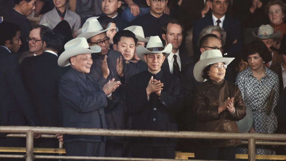 China's late paramount leader Deng Xiaoping (left), donning a cowboy hat, applauds at a Houston rodeo during a visit to the United States in 1979. - Wally McNamee/Corbis/Getty Images
