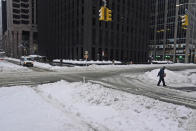 People and cars make their way through a snowy and mostly empty midtown Manhattan in New York, Tuesday, Feb. 2, 2021. Tuesday's snowfall comes as residents of the New York City region are digging out from under piles of snow that shut down public transport, canceled flights and closed coronavirus vaccination sites. (AP Photo/Seth Wenig)