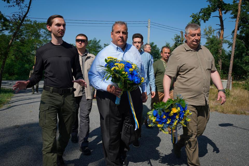 Republican presidential candidate former New Jersey Gov. Chris Christie, centre, participates in a flowers laying ceremony as he visits a former defence line from Russian massive offensive in March 2022 in the village of Moshchun, outskirts of Kyiv, Ukraine, Friday, Aug. 4, 2023. (AP Photo/Efrem Lukatsky)