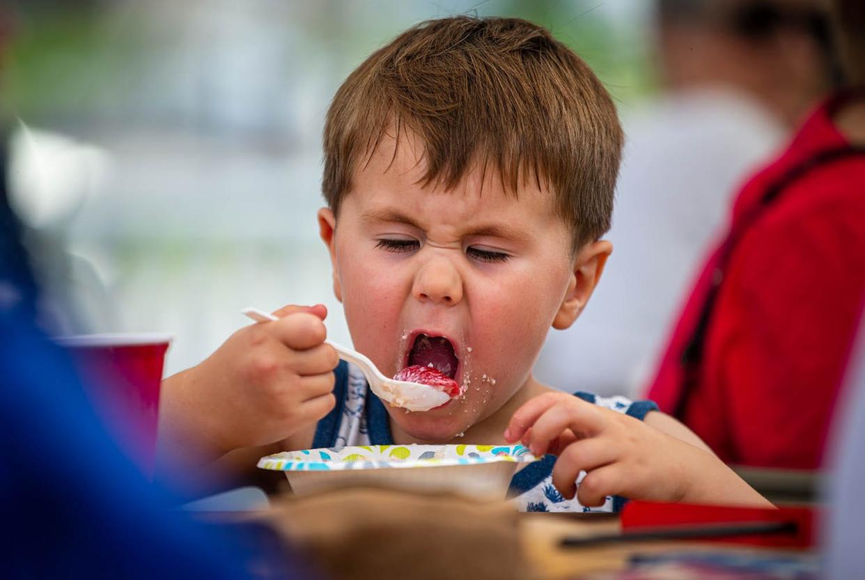 Declan Walling enjoys his strawberry shortcake during the annual "Clara Irwin's Strawberry Party" at the Elijah Iles House, Thursday, July 4, 2019, in Springfield, Ill.