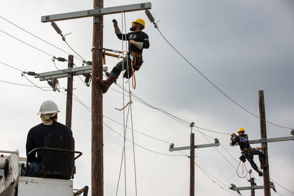 Andrew "Blake" Galvan, center, and Christopher Luzania, right, participate in a skills rodeo at Nueces Electric Cooperative's training field on April 4, 2023, in Robstown, Texas. They are two of four continuing education students to complete Del Mar College's first Entry Level Electrical Lineworker Program.