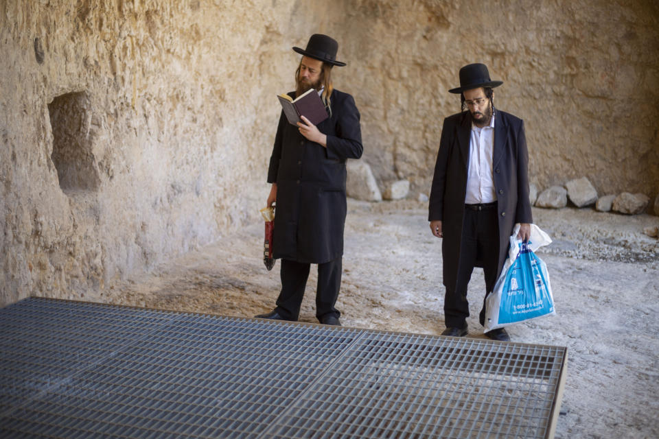 In this Thursday, Oct. 31, 2019 photo, ultra-Orthodox Jews pray in the Tomb of the Kings, a large underground burial complex dating to the first century BC, in east Jerusalem neighborhood of Sheikh Jarrah. After several aborted attempts, the French Consulate General has reopened one of Jerusalem's most magnificent ancient tombs to the public for the first time in over a decade, sparking a distinctly Jerusalem conflict over access to an archaeological-cum-holy site in the volatile city's eastern half. (AP Photo/Ariel Schalit)