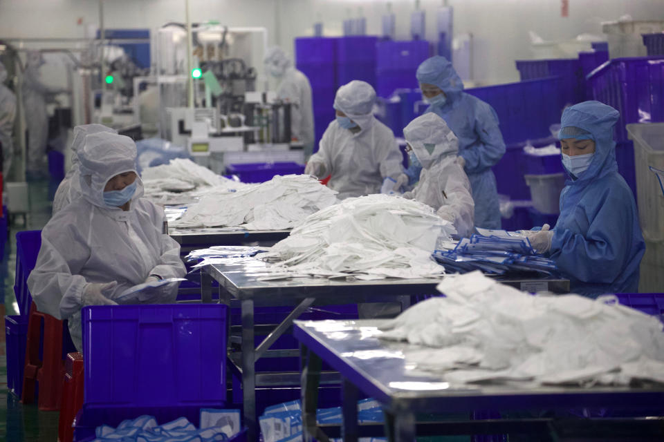 Workers labor in a clean room producing masks at a production line for the Wuhan Zonsen Medical Products Co. Ltd in Wuhan in central China's Hubei province on Sunday, April 12, 2020. Chinese regulators say ventilators, masks and other supplies being exported to fight the coronavirus will be subject to quality inspections following complaints shoddy or substandard goods were being sold abroad. (AP Photo/Ng Han Guan)