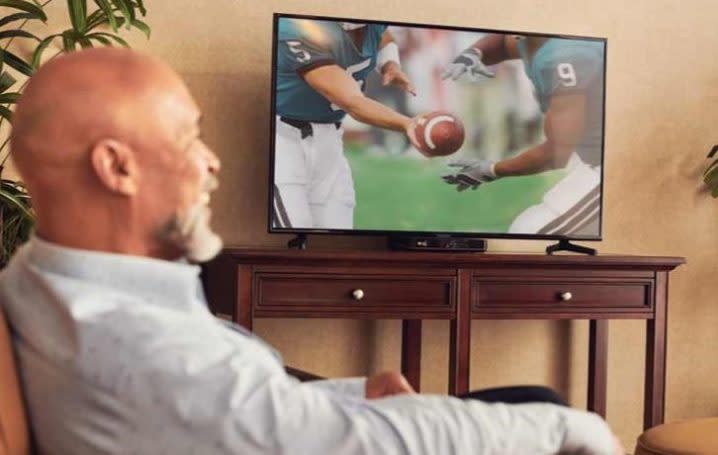 Man watching NFL on Dish.