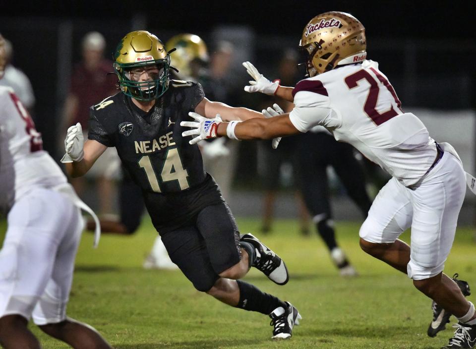 Nease wide receiver Maddox Spencer (14) tries to elude a tackle by St. Augustine safety Ja'ki Singleton during an October game.