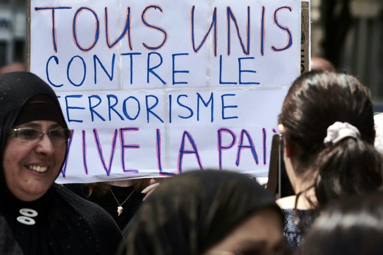 Demonstrators hold a placard reading "All united against terrorism, long live to peace" at a silent march in Lyon on July 30, 2016