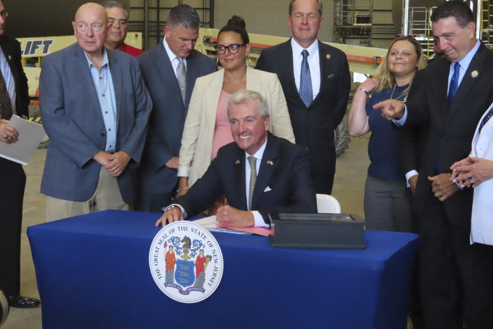 New Jersey Gov. Phil Murphy signs a bill in Paulsboro N.J. on July 6, 2023, granting a tax break to offshore wind energy developer Orsted. New Jersey's Cape May County and environmental and fishing industry groups are suing the federal government to try to overturn its approval New Jersey's first offshore wind farm, which would be built by Danish company Orsted. (AP Photo/Wayne Parry)