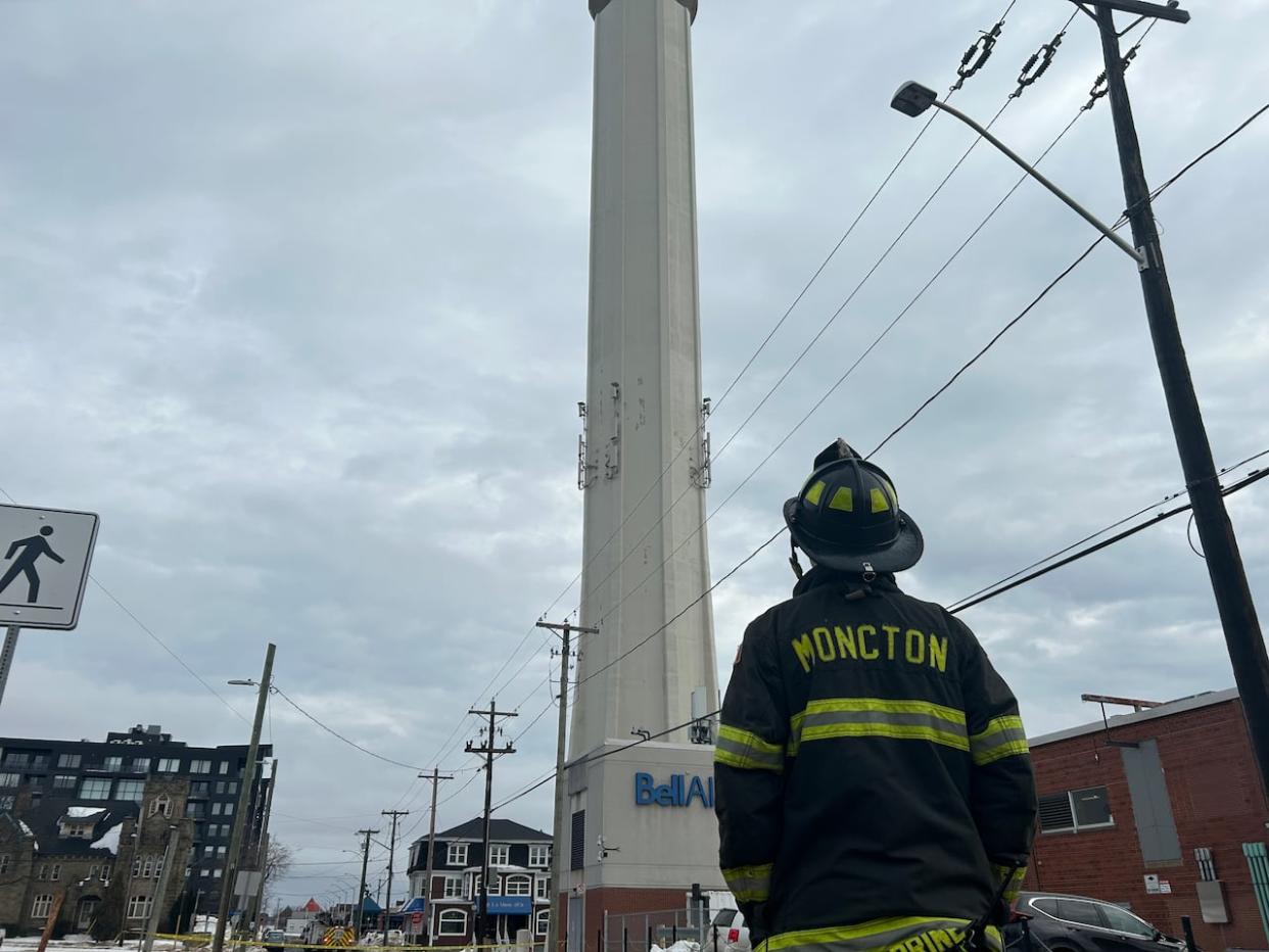 Moncton Fire Department Capt. Serge Boudreau watches for falling ice from the Bell Aliant Tower.  (Babatunde Lawani/Radio-Canada - image credit)