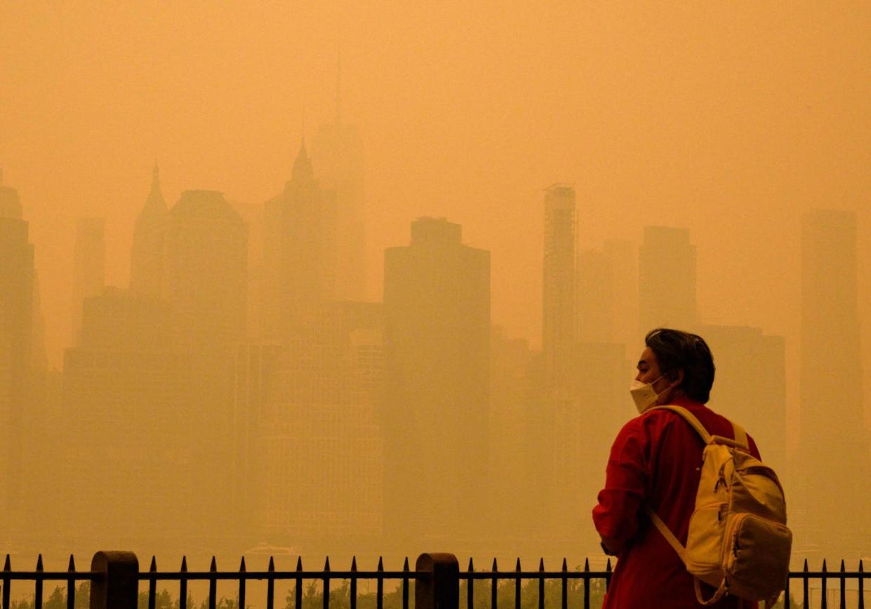 People wore face masks as wildfire smoke from Canada turned New York City's sky orange on June 7, 2023. <a href="https://www.gettyimages.com/detail/news-photo/person-wears-a-face-mask-as-smoke-from-wildfires-in-canada-news-photo/1258513476" rel="nofollow noopener" target="_blank" data-ylk="slk:Angela Weiss/AFP via Getty Images;elm:context_link;itc:0;sec:content-canvas" class="link ">Angela Weiss/AFP via Getty Images</a>