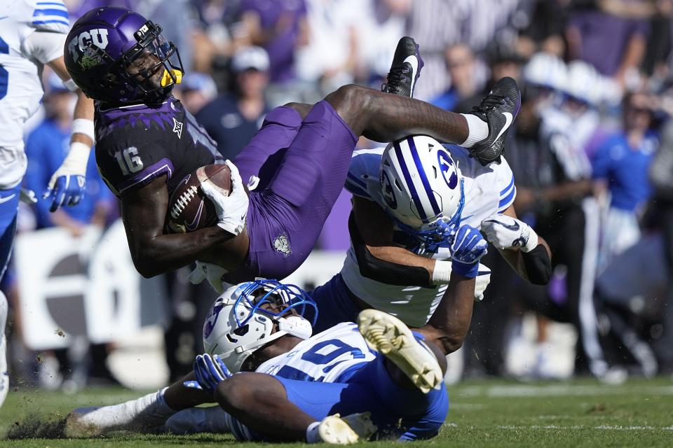TCU wide receiver Dylan Wright (16) comes down with the ball after making a catch against BYU defenders Mory Bamba (19) and Preston Rex during the first half of an NCAA college football game Saturday, Oct. 14, 2023, in Fort Worth, Texas. | LM Otero, Associated Press