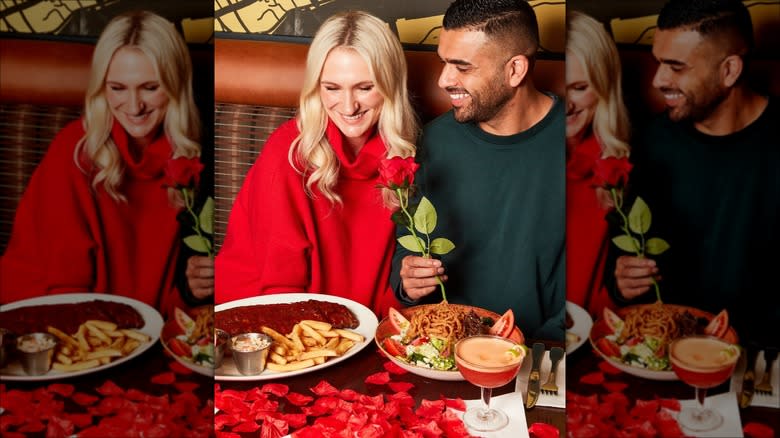 Couple at rose petal-covered table