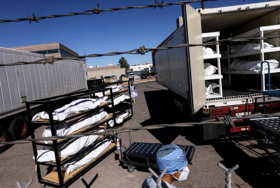 Cuerpos de fallecidos por covid-19 son trasladados a camiones refrigerados colocados junto a la morgue de El Paso, Texas. Tanta es la cantidad de personas que han muerto en esa ciudad fronteriza que se ha debido recurrir a esos camiones y al trabajo de presos para transladar los cuerpos. (Mario Tama/Getty Images)