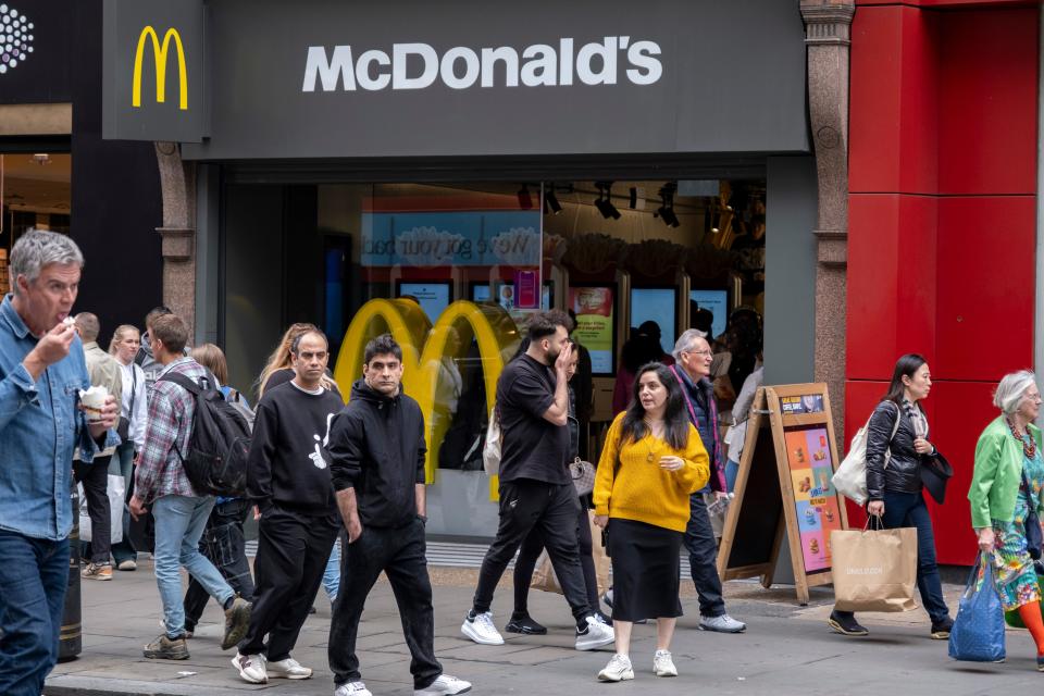 people standing outside of a mcdonald's location in london