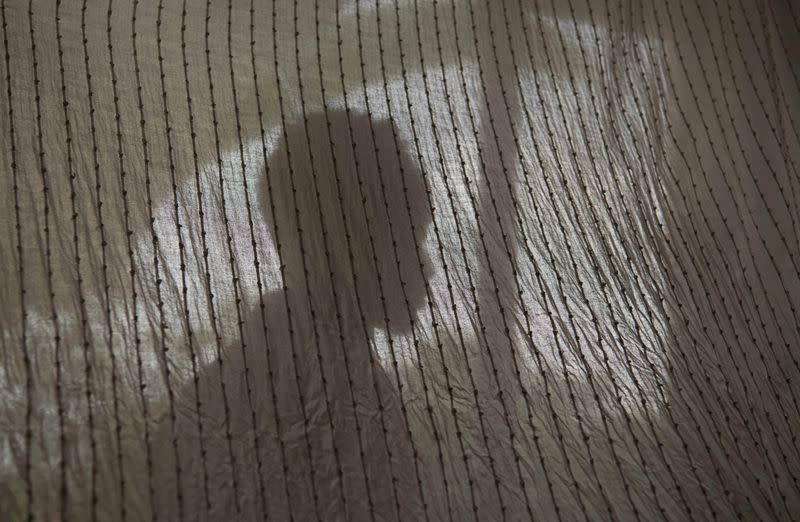 FILE PHOTO: An Eritrean refugee poses for a portrait behind a curtain in Addis Ababa, Ethiopia