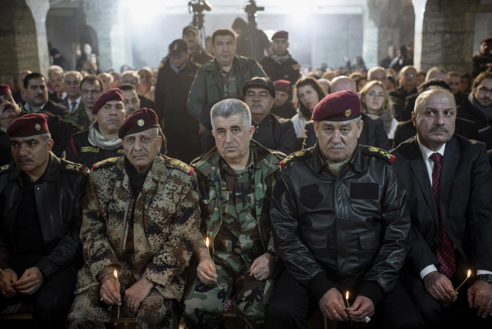 Iraqi Army and Peshmerga commanders attend Christmas Eve's Mass in the Assyrian Orthodox church of Mart Shmoni, in Bartella, Iraq, Saturday, December 24, 2016. For the 300 Christians who braved rain and wind to attend the mass in their hometown, the ceremony provided them with as much holiday cheer as grim reminders of the war still raging on around their northern Iraqi town and the distant prospect of moving back home. Displaced when the Islamic State seized their town in 2014, they were bused into the town from Irbil, capital of the self-ruled Kurdish region, where they have lived for more than two years. (AP Photo/Cengiz Yar)